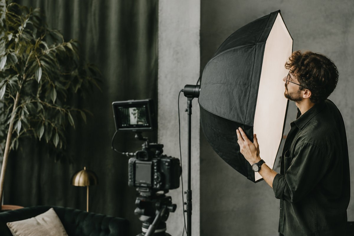 Cinematographer adjusting a studio softbox beside camera